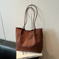 Minimalist brown suede tote bag featuring a spacious interior and long slender shoulder handles - Brown