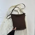 Detailansicht der dunkelbraunen Wildleder-Beuteltasche mit vier silbernen Metallfüßen - Braun