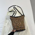 Detail der Tragetasche mit Leopardenmuster, schwarzem Rand und silbernen Bodennieten - Leopard Braun