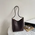 Sac seau rétro marron foncé avec détails argentés dans un décor urbain chic - Sans Pendentif / Café