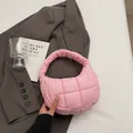 Chic pink quilted puffer crescent handbag with padded texture in a minimalist lifestyle setting - Pink