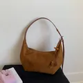 Detalle de bolso hobo de ante marrón con borla étnica y decoración de cuentas de madera - Marrón