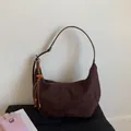 Primer plano del bolso de gamuza con borla de cuentas de madera y detalle de cremallera - Marrón