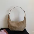 Detalle de bolso hobo de ante marrón con borla de cuentas de madera y textura mate - Caqui