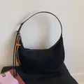 Primer plano de la textura de ante negro del bolso hobo con colgante de madera - Negro