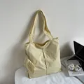 Hellgelbe gefaltete Tragetasche mit kleinem Reißverschlussbeutel in lässigem Lifestyle-Stil - Hellgelb