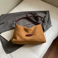 Brown suede underarm tote bag with dark red straps and stylish metal logo detail - Brown