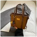 Vintage brown bucket bag in mixed leather finish with gold plaque and floral charm - With Pendant / Brown