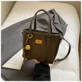 Minimalist olive green bucket bag with yellow floral charm and gold metal plaque - With Pendant / Green