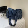 Grande borsa a tracolla vintage in denim lavato blu scuro con ampia cinghia nera - Blu