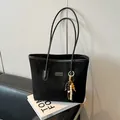 Borsa tote nera in finto scamosciato con nappa di perline e logo argentato - Nero