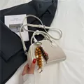 Minimalistische beige kussentas met retro textuur en etnische kralenbedel - Met Hanger / Broken Wit