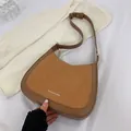Detailed top view of a brown suede crescent bag with FASHION & BAG lettering and gold hardware - Brown