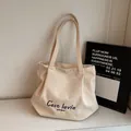 Chique beige canvas emmer tas met blauwe 'C'est la vie' letters en zachte plooien - Rijstwit (Geen Hanger)