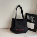 Modieuze zwarte canvas bucket bag met rood geborduurde letters voor dames, casual - Zwart zonder Hanger