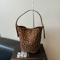 Bolso cubo de ante con estampado de leopardo, correa de cuero marrón y hebilla dorada - Estampado de leopardo
