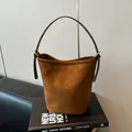 Bolso tipo cubo de ante marrón con correa de cuero fina y acabado mate de estilo retro - Marrón