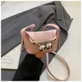 Top view of pink mini clasp bag with large silver spherical fasteners on gray blazer - Pink