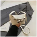 Detail of a cream leather mini frame bag with distinctive large silver ball clasps - White