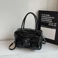 Glossy black hobo shoulder bag with bow accents and functional front pockets - Black