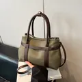 Tragetasche aus olivgrünem Canvas und braunem Leder mit Griffen und verstellbarem Gurt - Grün