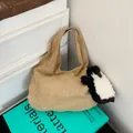 Retro camel suede tote bag with cute penguin charm on minimalist blue book background - Khaki With Pendant