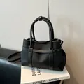 Minimalistische Tragetasche aus schwarzem Canvas und Leder mit Griffen und Schultergurt - Schwarz
