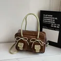 Chic dark brown faux leather hobo bag featuring green bow accents and dual front pockets - Coffee