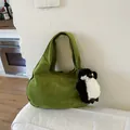 Grass green suede tote bag with a cute penguin plush charm in a cozy home setting - Green with Charm