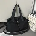 Detail of black multi-functional travel bag with drawstring closure and metal buckle - Black