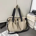 Close-up of khaki large capacity travel tote bag with drawstring side pockets and black strap - Khaki