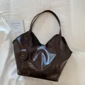 Detail der glänzenden kaffeebraunen Ledertasche mit rundem Münzfach auf weißem Stoff - Braun