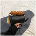 Black cylinder shoulder bag with plush baguette decor and cookie charm in black PU leather - Black