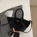 Schwarze Handtasche aus Wildlederoptik mit goldenem Verschluss und Schultergurt - Schwarz