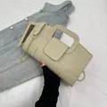 Close-up of beige quilted shoulder bag featuring crocodile texture and gold chain link - Beige