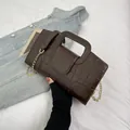 Detail of dark brown crocodile embossed texture handbag with gold chain strap - Brown