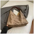 Borsa tote in tela marrone maculata con manici in pelle scura su blazer grigio - Marrone