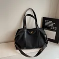 Black canvas tote bag with leather straps and gold zippers in a minimalist style - Black