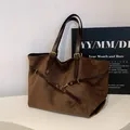 Brown suede tote bag featuring adjustable leather straps and vintage gold hardware - Brown