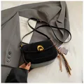 Black minimalist saddle bag with golden horseshoe buckle and leopard tassel detail - Black With Pendant