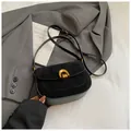 Minimalist black suede saddle bag with vintage gold buckle on a stylish blazer - Black without Pendant