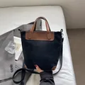 Bolso tote grande de lona negra con detalles en cuero marrón y correa ancha ajustable - Negro