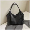 Bolso tote negro de piel sintética con asa trenzada y detalles de borlas elegantes - Negro