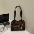 Chic leopard print shoulder bag with black trim and decorative beaded charms - Black & Brown With Charm