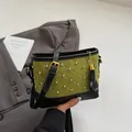 Quilted green bucket bag with rhinestones and gold chain fringe detail in hand - Green