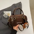 Dark brown suede bowling bag with white letter embroidery and a plush bear charm - With Pendant / Brown