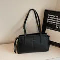 Minimalist black leather tote bag with drawstring details and gold-tone hardware - Black