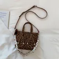 Detail of leopard print tote bag with brown leather straps and beaded chain accent - Leopard Print
