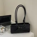 Bolso de hombro minimalista de cuero sintético negro con hebilla dorada en mesa - Negro