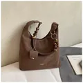 Detail der dunkelbraunen Wildleder-Tote mit Holzperlen und Metallring am Riemen - Braun